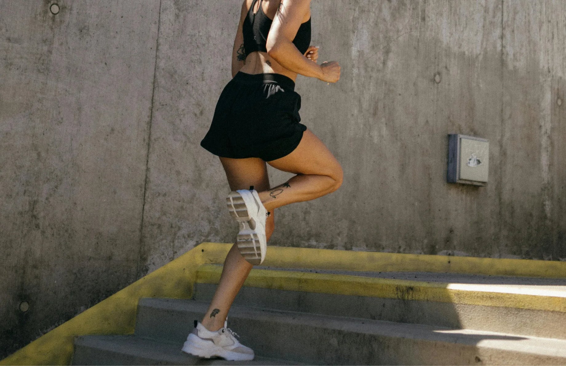 Athletic woman running up stairs, supporting muscle recovery and endurance with probiotics