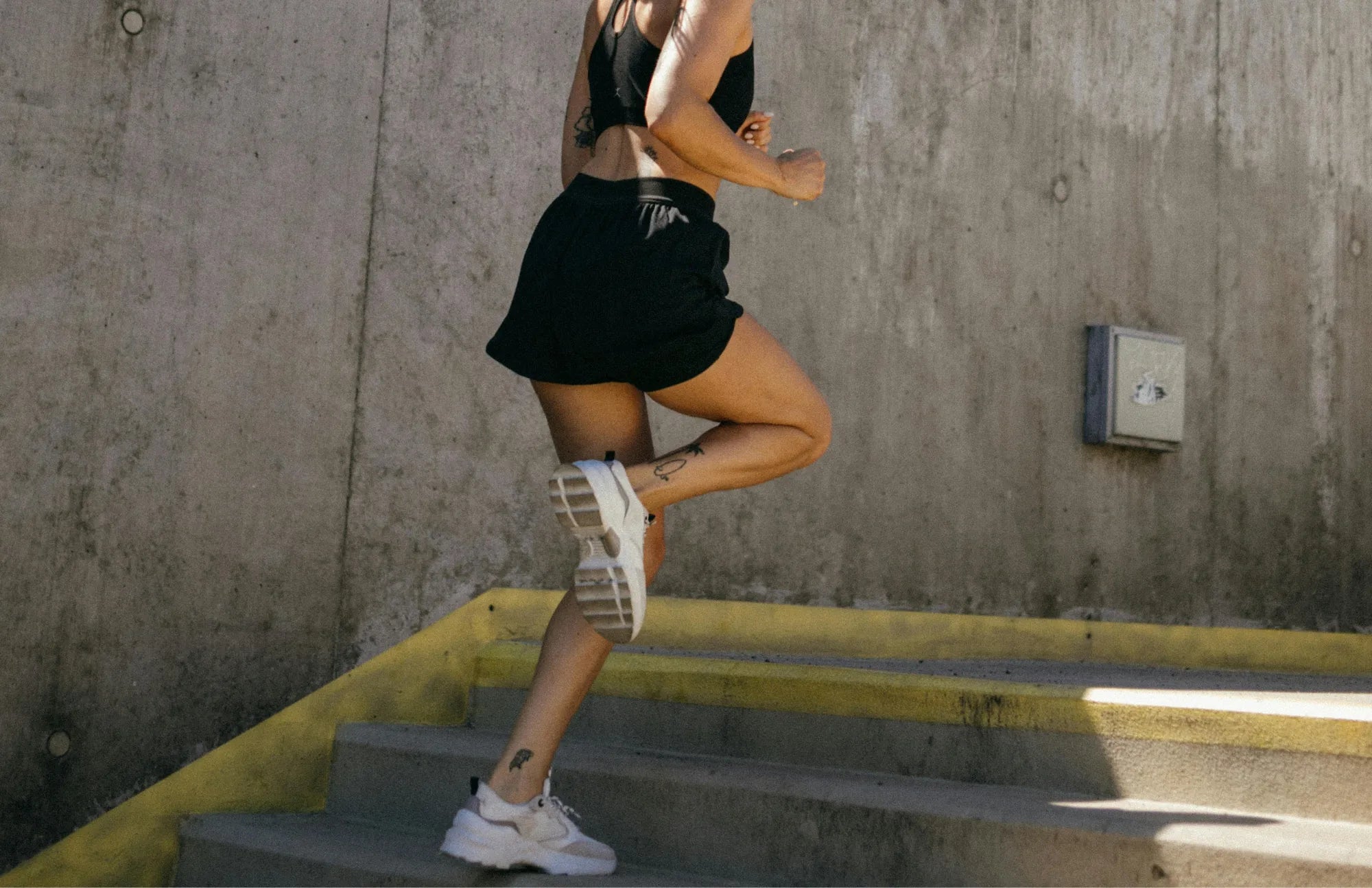 Athletic woman running up stairs, supporting muscle recovery and endurance with probiotics