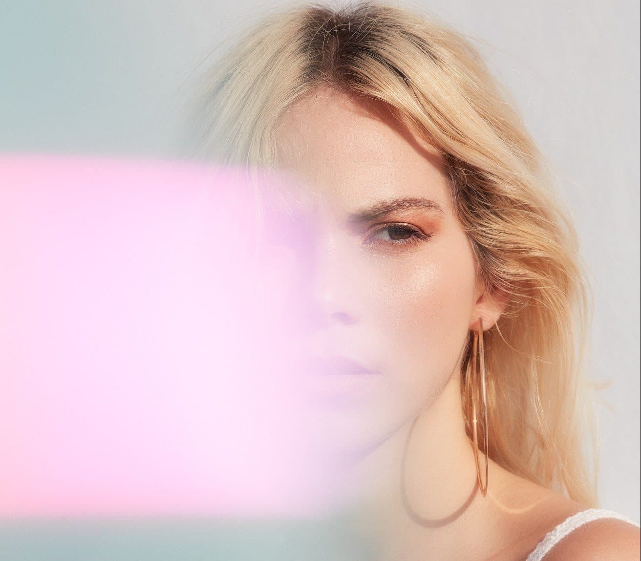 portrait-of-blonde-woman-with-pink-lens-flare-covering-half-of-her-face