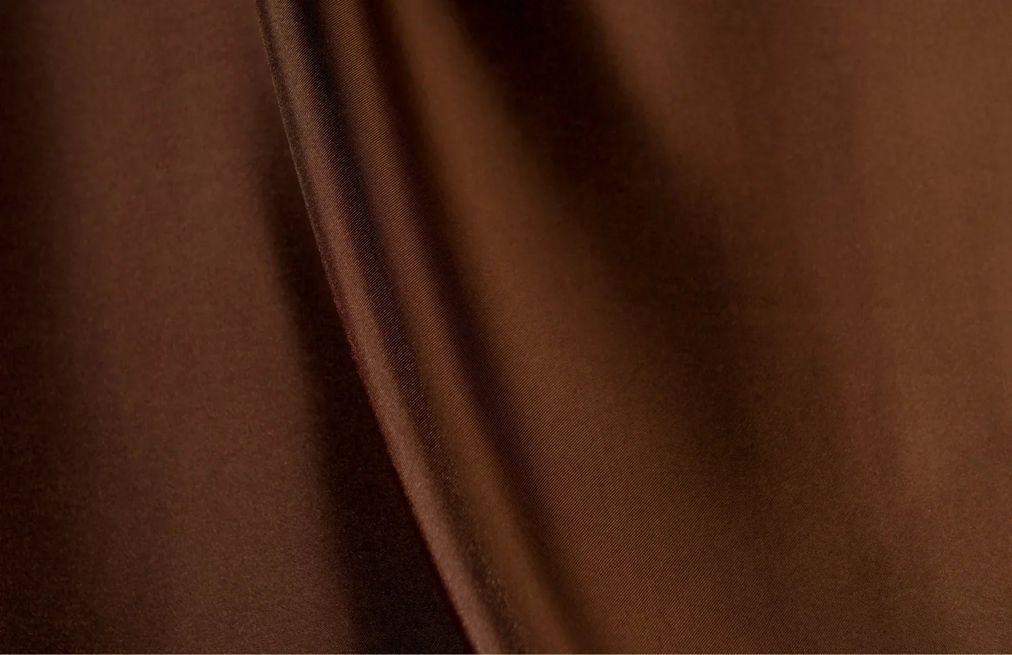 Close-up texture of dark brown fabric suggesting natural simplicity and calm.