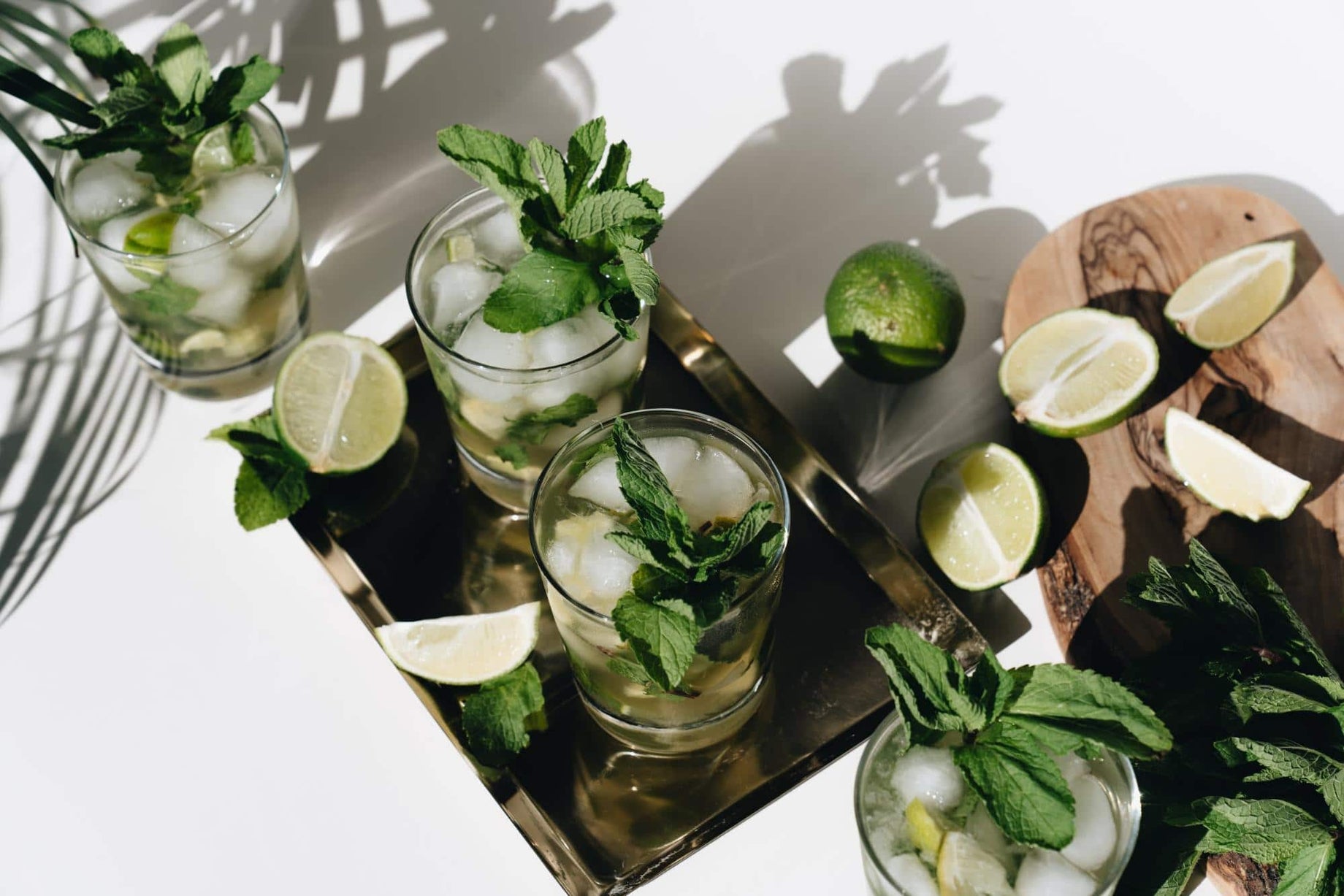 alcoholic drinks with fresh mint leaves and limes