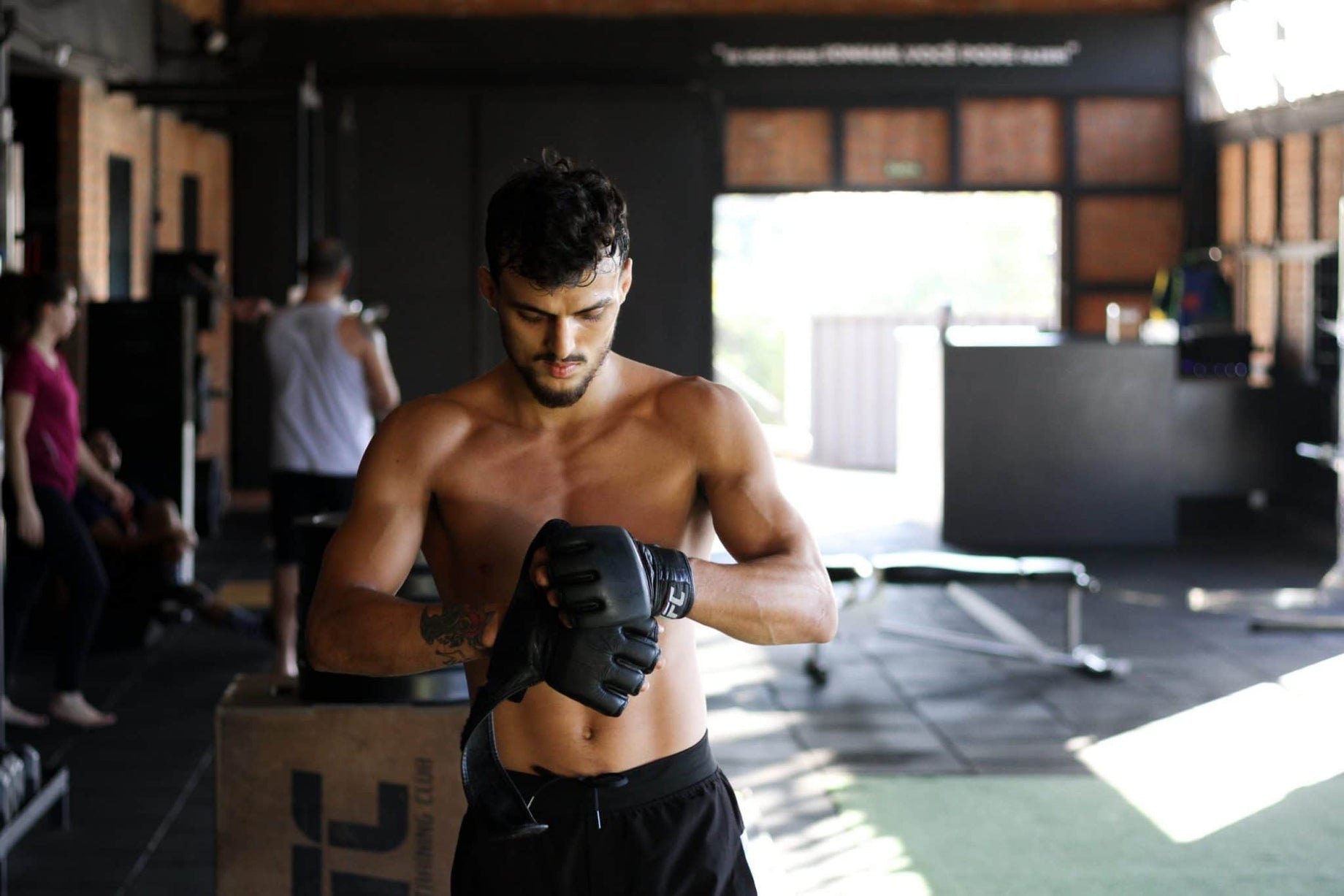 man-standing-in-gym-wearing-black-boxing-gloves