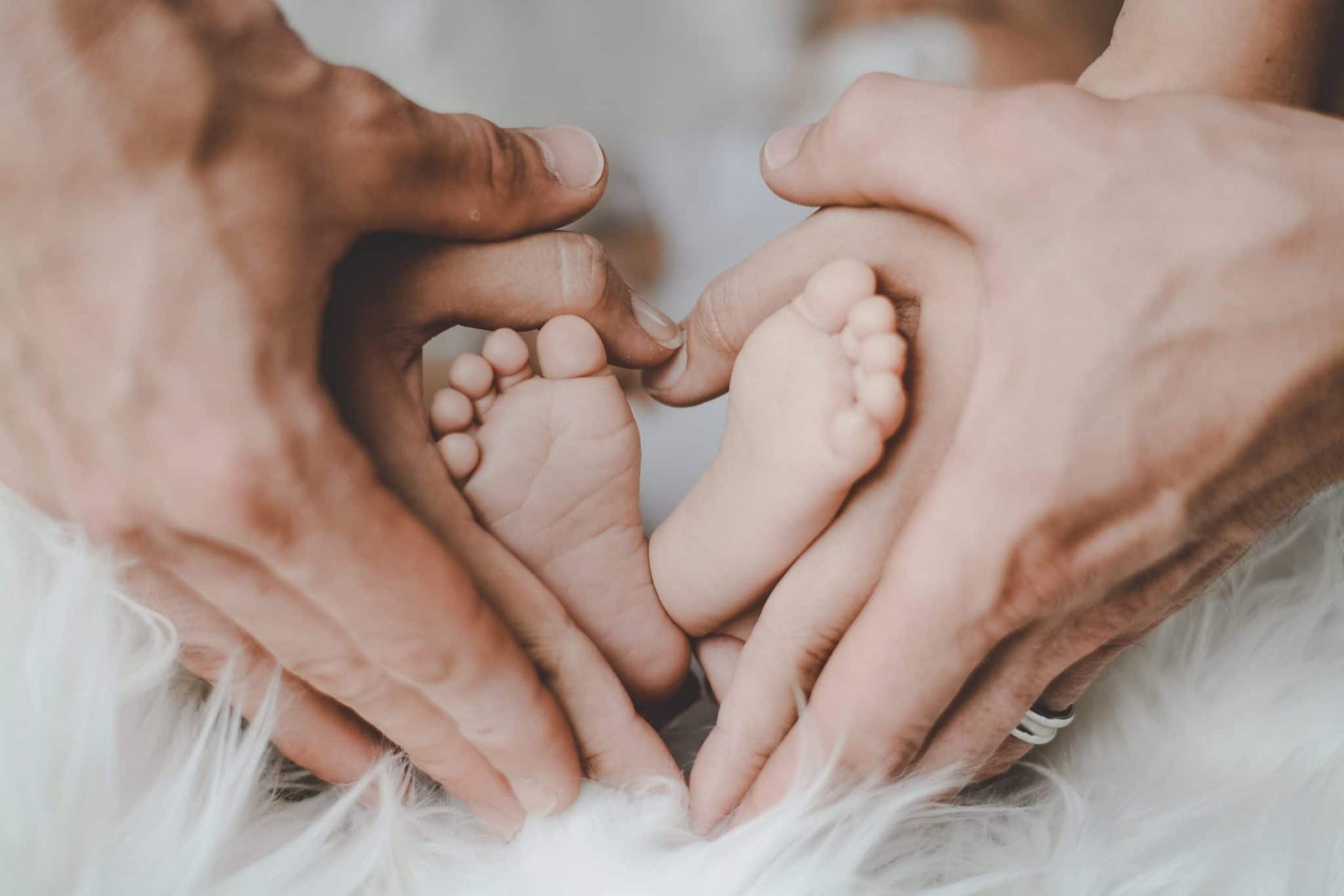 Mother and father embrace newborn baby's feet