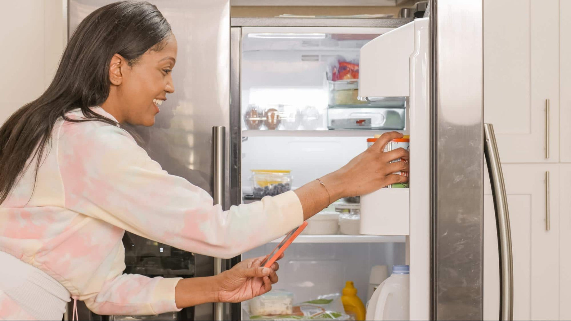 Black Woman getting in refrigerator, reaching for yogurt